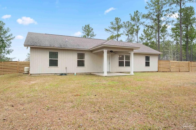 back of property featuring ceiling fan, a patio area, and a lawn