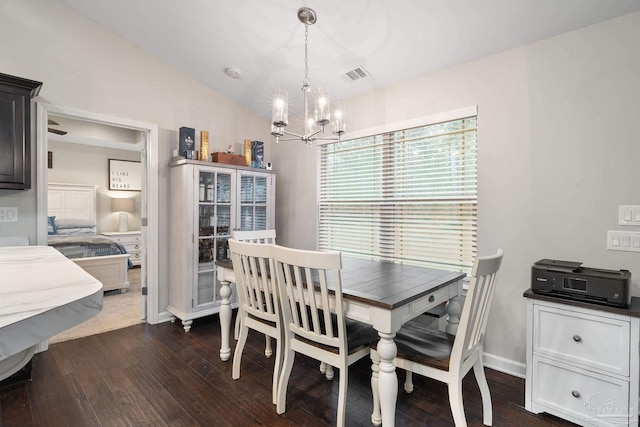 dining space featuring dark wood-type flooring and a chandelier