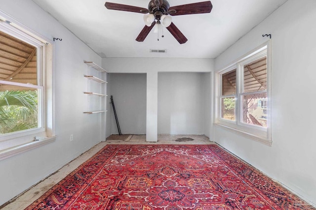 unfurnished room featuring plenty of natural light and ceiling fan