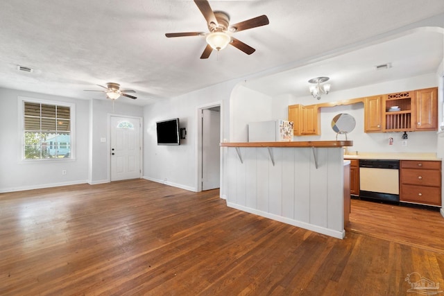 kitchen with a kitchen breakfast bar, dark hardwood / wood-style flooring, ceiling fan, and white appliances