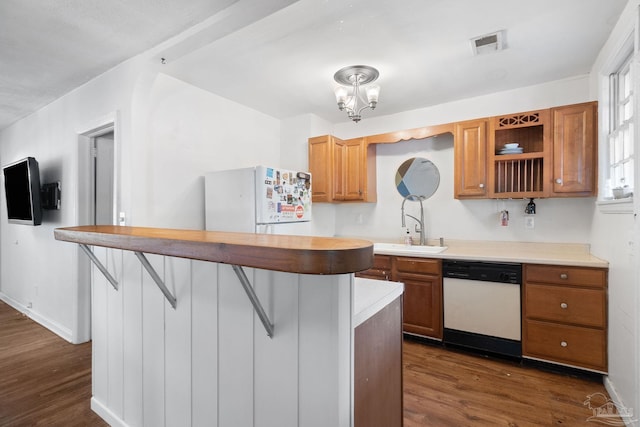 kitchen featuring white appliances, sink, a breakfast bar, and dark hardwood / wood-style floors