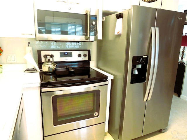 kitchen featuring stainless steel appliances and white cabinets