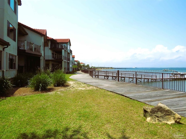 dock area with a water view and a lawn