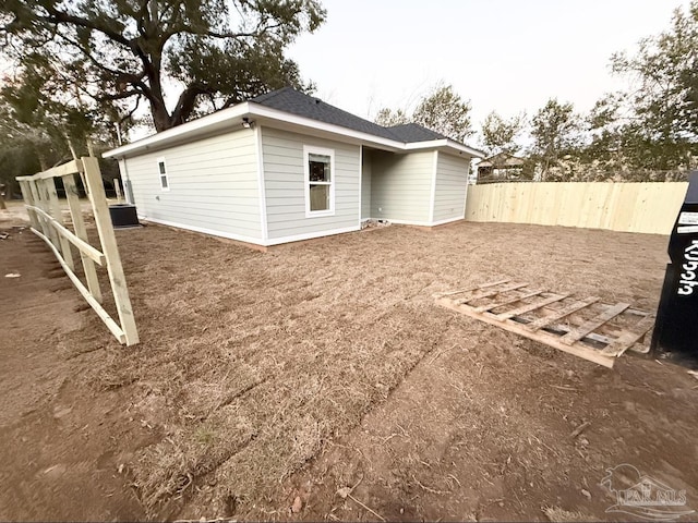 back of property with central air condition unit and fence