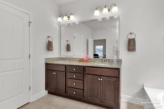 bathroom with double vanity, a sink, and baseboards