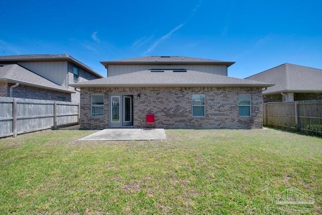 rear view of house featuring a yard, a fenced backyard, a patio, and brick siding