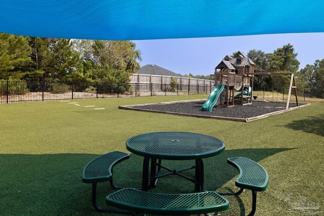 community playground featuring a yard and fence