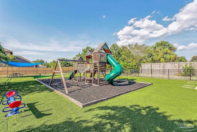 community jungle gym with a yard and fence