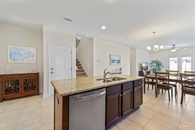 kitchen featuring visible vents, hanging light fixtures, stainless steel dishwasher, a kitchen island with sink, and a sink