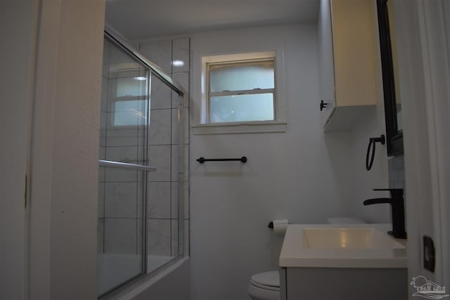 full bath with toilet, shower / bath combination with glass door, and vanity