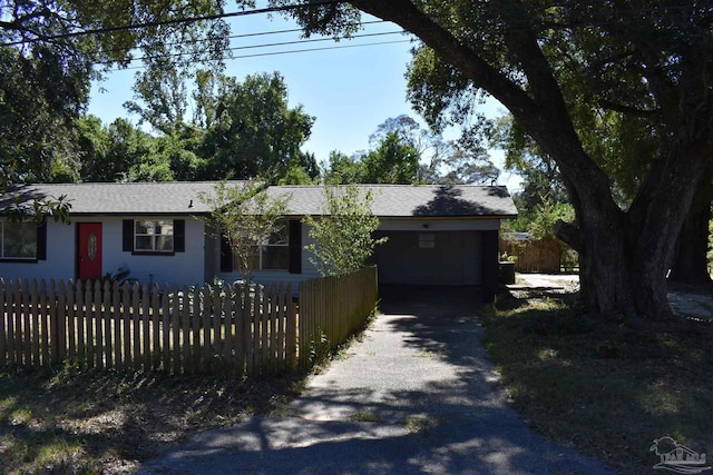 ranch-style house with fence private yard, aphalt driveway, and a carport