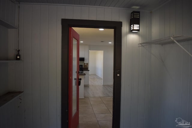 hallway featuring wooden walls and light wood-type flooring