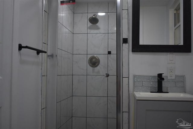 bathroom featuring tiled shower and vanity