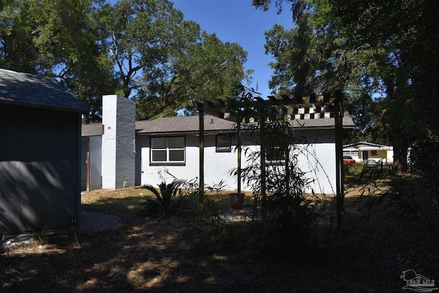 view of home's exterior with roof with shingles and a chimney