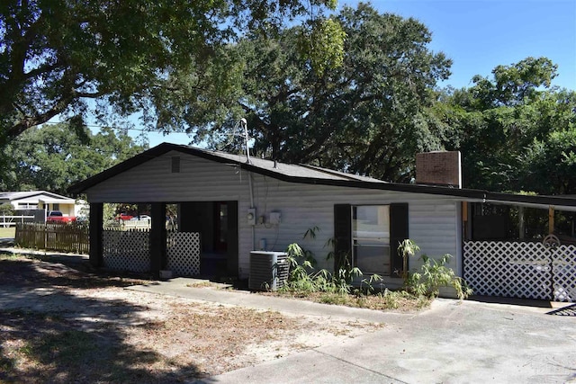 view of front facade with fence and central AC