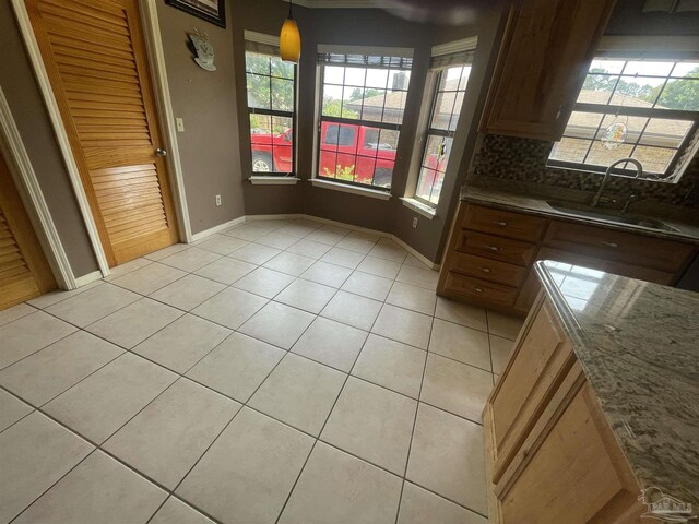 7844 Bay Meadows Dr, Pensacola, FL 32507 - unfurnished dining area featuring baseboards, a sink, and light tile patterned floors