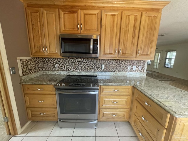 7844 Bay Meadows Dr, Pensacola, FL 32507 - kitchen featuring light stone counters, tasteful backsplash, and stainless steel appliances