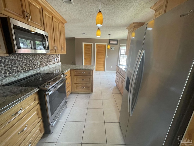 7844 Bay Meadows Dr, Pensacola, FL 32507 - kitchen with stainless steel appliances, a peninsula, decorative backsplash, pendant lighting, and light tile patterned floors