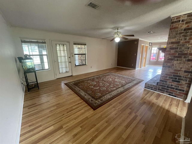 7844 Bay Meadows Dr, Pensacola, FL 32507 - unfurnished living room with a textured ceiling, baseboards, visible vents, a ceiling fan, and wood finished floors