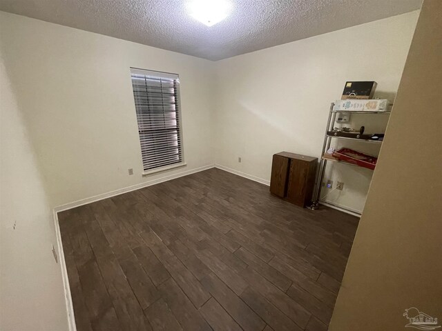 7844 Bay Meadows Dr, Pensacola, FL 32507 - empty room with baseboards, a textured ceiling, and dark wood finished floors
