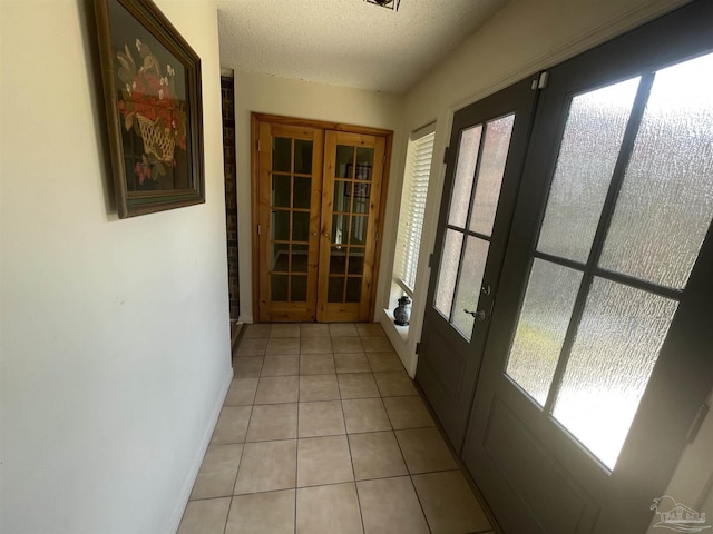 7844 Bay Meadows Dr, Pensacola, FL 32507 - doorway to outside featuring french doors, baseboards, a textured ceiling, and light tile patterned floors