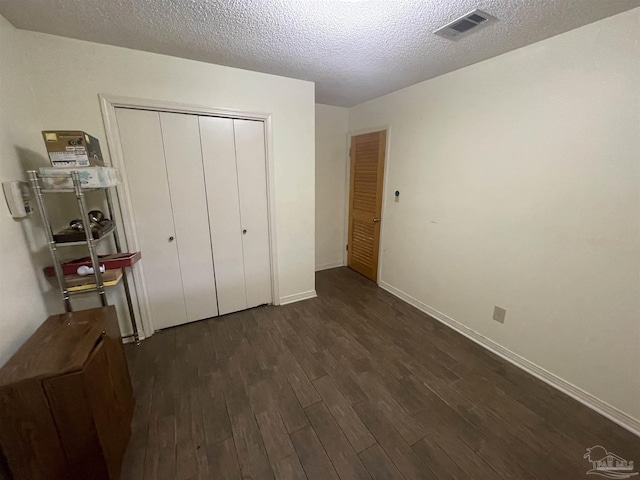7844 Bay Meadows Dr, Pensacola, FL 32507 - bedroom with dark wood-style floors, visible vents, a closet, baseboards, and a textured ceiling