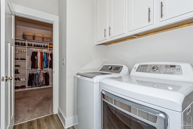 washroom with cabinets, dark hardwood / wood-style flooring, and washer and clothes dryer