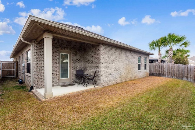 back of property featuring a lawn and a patio area