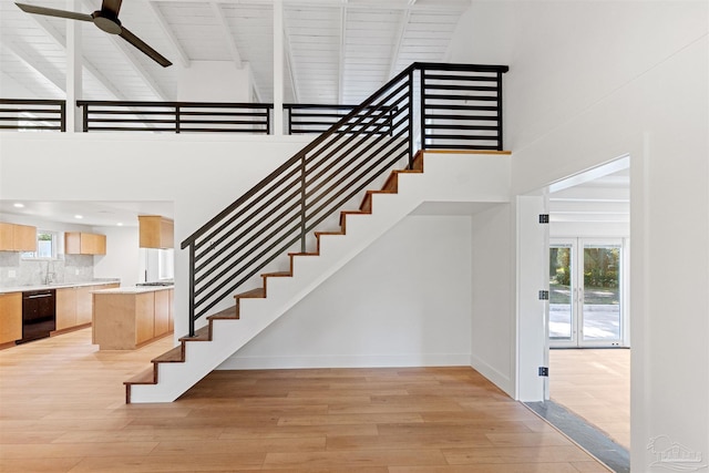 stairway featuring beamed ceiling, sink, high vaulted ceiling, and hardwood / wood-style floors