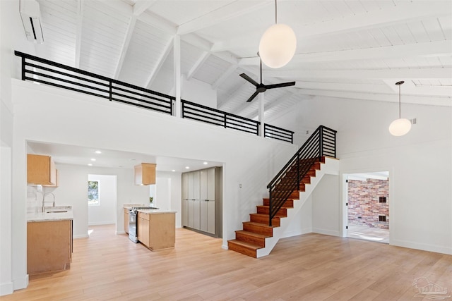 stairs with sink, high vaulted ceiling, hardwood / wood-style floors, and ceiling fan