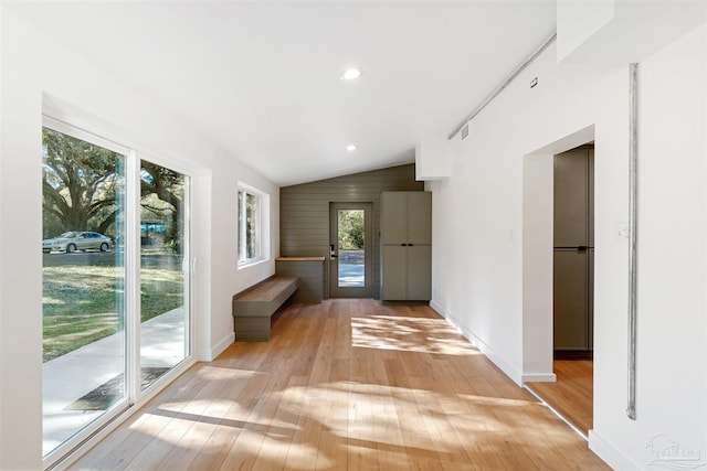 corridor featuring vaulted ceiling and light hardwood / wood-style flooring