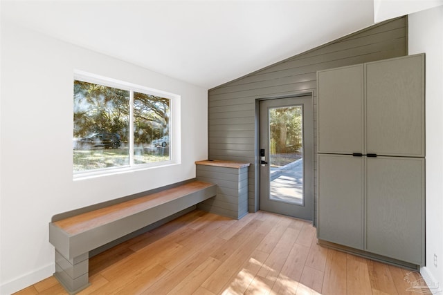 doorway featuring vaulted ceiling and light hardwood / wood-style floors