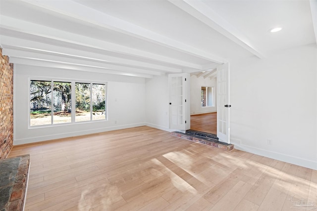 unfurnished living room with french doors, beam ceiling, and light hardwood / wood-style floors