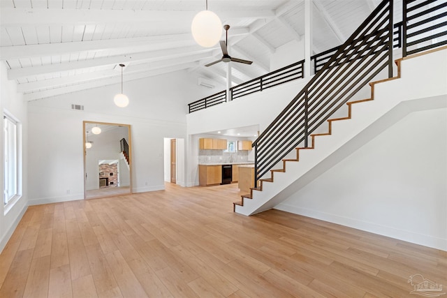 unfurnished living room with light hardwood / wood-style flooring, high vaulted ceiling, and ceiling fan