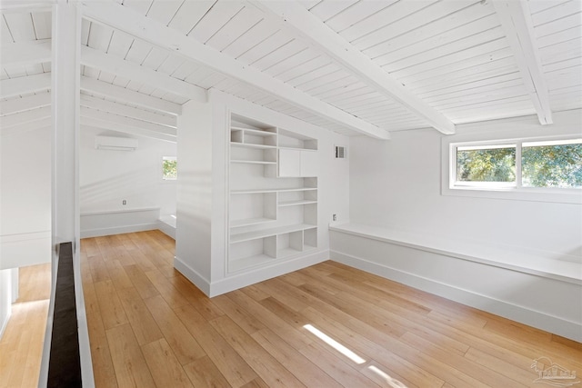 interior space with a wall mounted air conditioner, wood ceiling, wood-type flooring, and lofted ceiling with beams