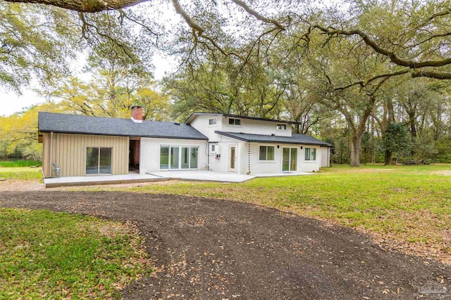 back of house featuring a patio and a yard