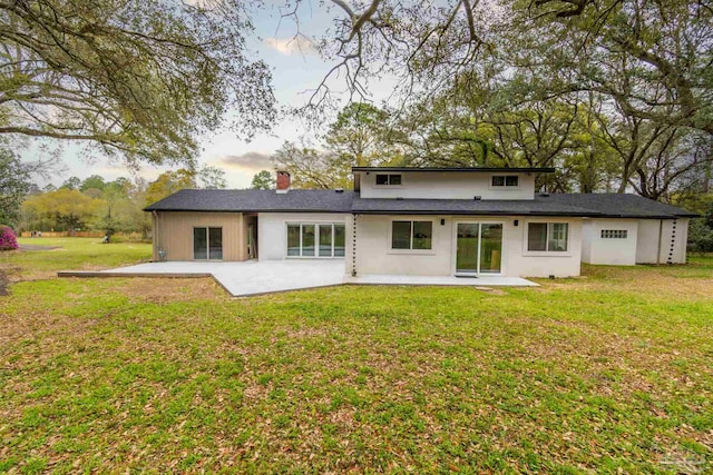 back of property featuring a patio and a yard