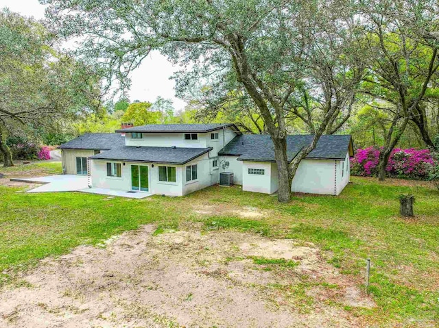 rear view of house featuring central AC unit, a patio area, and a lawn