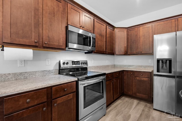 kitchen featuring appliances with stainless steel finishes and light wood-style flooring