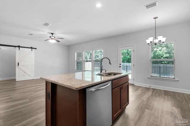 kitchen featuring dishwasher, visible vents, wood finished floors, and a sink
