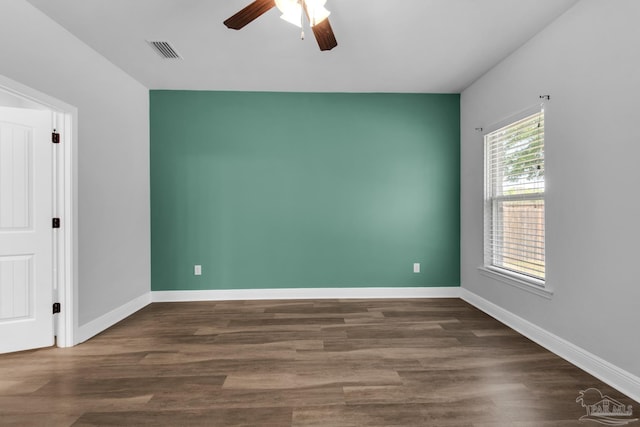 unfurnished room with ceiling fan, baseboards, wood finished floors, and visible vents