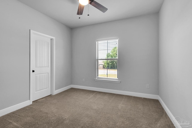carpeted spare room with baseboards and ceiling fan