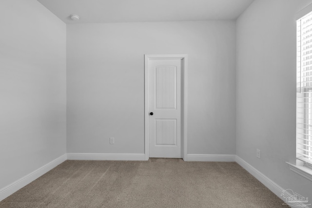 empty room with baseboards and carpet flooring