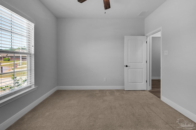 unfurnished room featuring a wealth of natural light, baseboards, carpet, and ceiling fan