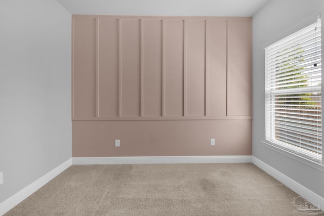 unfurnished room featuring light carpet and baseboards