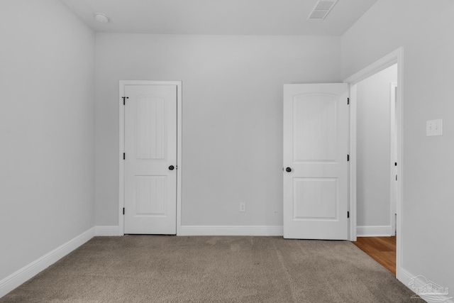 unfurnished bedroom with carpet, visible vents, and baseboards