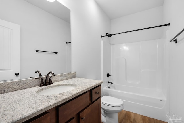 bathroom with bathing tub / shower combination, wood finished floors, vanity, and toilet