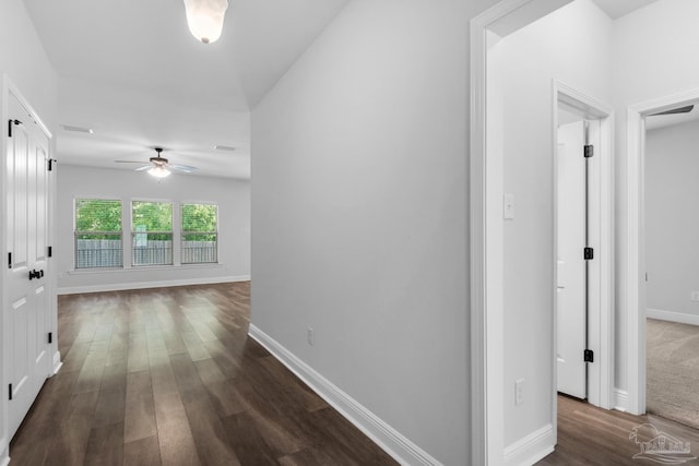 hallway with baseboards and dark wood-style flooring