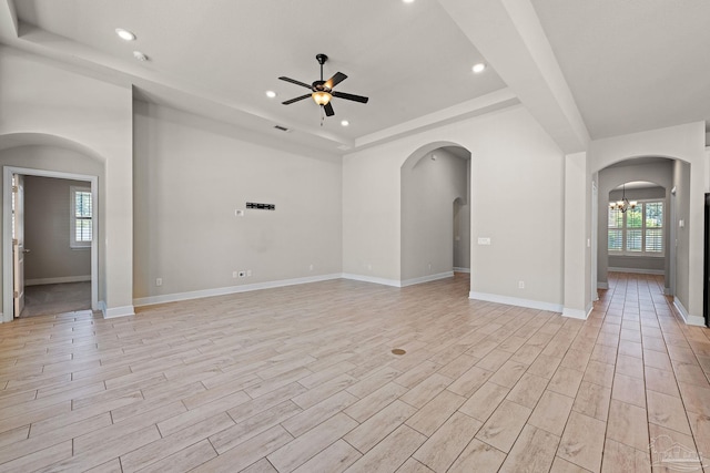 12789 Island Spirit Dr, Pensacola, FL 32506 - spare room with light wood-style flooring, arched walkways, recessed lighting, ceiling fan with notable chandelier, and a raised ceiling