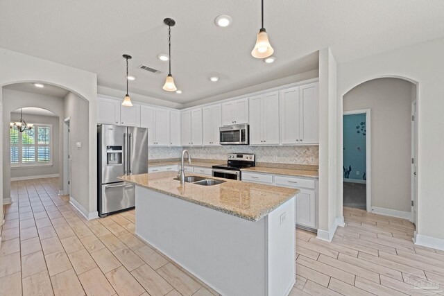 12789 Island Spirit Dr, Pensacola, FL 32506 - kitchen featuring stainless steel appliances, a sink, arched walkways, visible vents, and wood finish floors